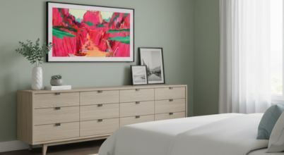 A Samsung The Frame TV in standby Art Mode wall mounted in a bedroom in daylight