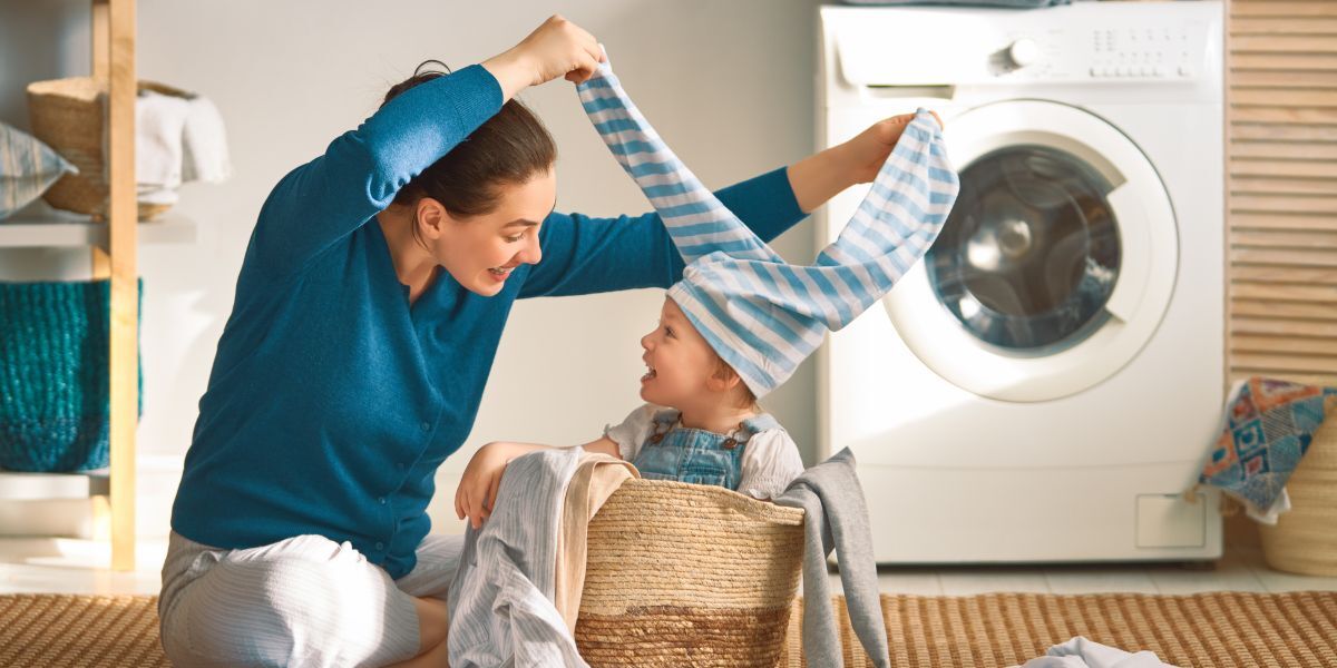 A happy woman and child do laundry