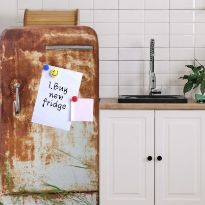 A rusty old fridge with a 'to-do' list stuck to it that reads 'Buy new fridge'