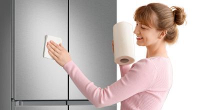 A woman cleans a fridge with recessed handles